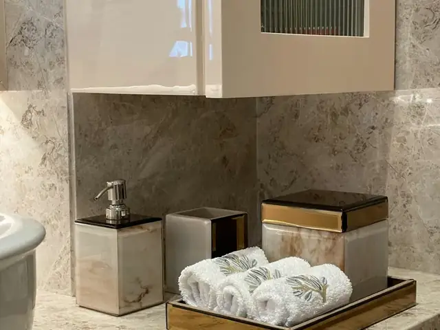 Rolled towels and bath accessories on a countertop tray