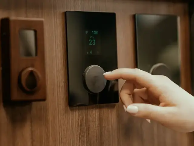 Hand using a modern wall-mounted control panel