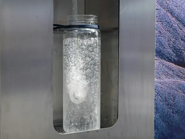 Wall-mounted water dispenser filling a glass