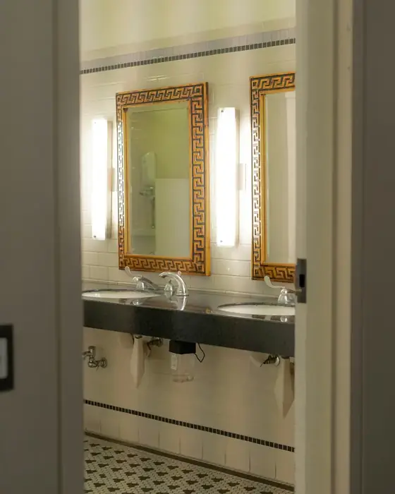 Twin basins with gold-framed mirrors and mosaic floor